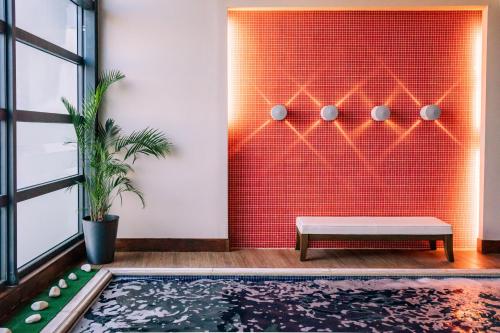 a living room with a bench and a red wall at Domotel Xenia Volos in Volos