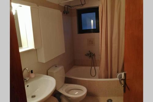 a bathroom with a toilet and a tub and a sink at Strofi House in Argoulés