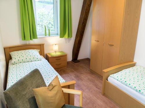 um quarto com 2 camas e uma janela com cortinas verdes em Ferienhof Heimes em Lennestadt