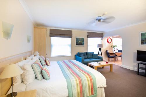 a bedroom with a bed, chair, and a television at SACO Jersey - Merlin House in Saint Helier Jersey