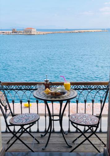 a table and chairs on a balcony with a view of the water at Filoxenia Hotel in Chios