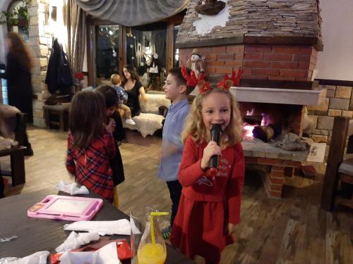 a little girl holding a microphone in a living room at Horlog Castle in Trigrad