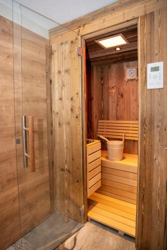 a wooden sauna with a tub in a room at Appartementhaus AURUM - Summercard included in Zell am See