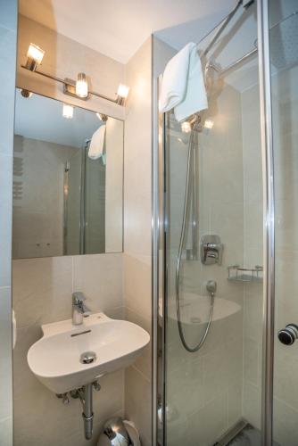 a bathroom with a sink and a shower at Appartementhaus AURUM - Summercard included in Zell am See