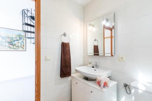 a white bathroom with a sink and a mirror at Vilar - Xiprer in El Port