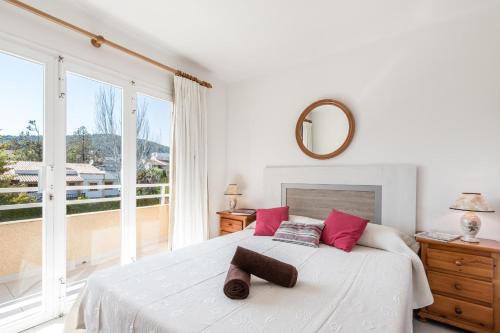a bedroom with a white bed with a large window at Vilar - Xiprer in El Port