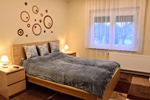 1 dormitorio con 1 cama, 2 mesitas de noche y ventana en Kéknefelejcs Vendégház en Zalakaros