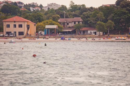a group of people in the water at a beach at HI Hostel Pula in Pula