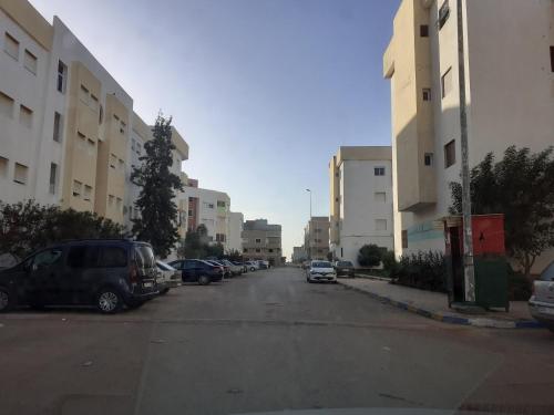 a parking lot with cars parked in front of buildings at Apartamento con wifi in Nador