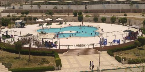 a large swimming pool with people in it at Minya Compound of the Armed Forces in Minya