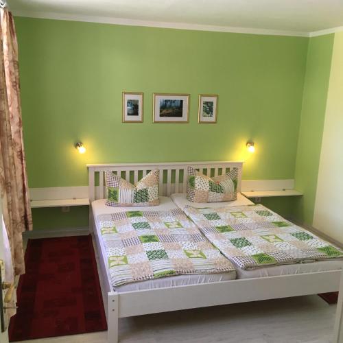 a bedroom with a bed with green walls at Ferienwohnungen Weber in Friedrichsbrunn