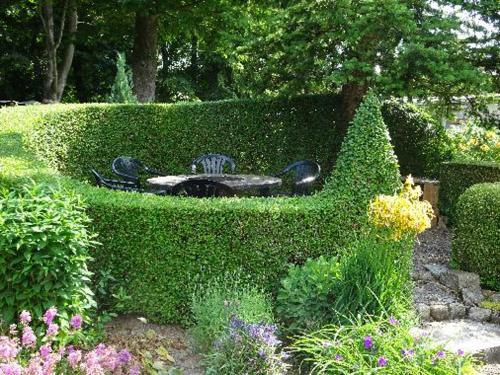 a hedge with a fountain in the middle of a garden at Ferienwohnungen Weber in Friedrichsbrunn