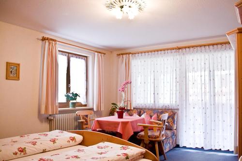 a bedroom with a table and a bed and a window at Ferienwohnungen Gästehaus Schraudolf in Oberstdorf