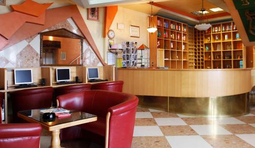 ein Restaurant mit einer Bar mit roten Stühlen und einer Theke in der Unterkunft Hotel BM in Sarajevo
