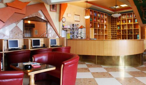 a restaurant with a bar with red chairs and a counter at Hotel BM in Sarajevo