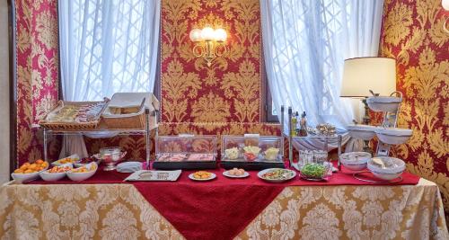 a table with plates of food on top of it at Hotel Bel Sito e Berlino in Venice