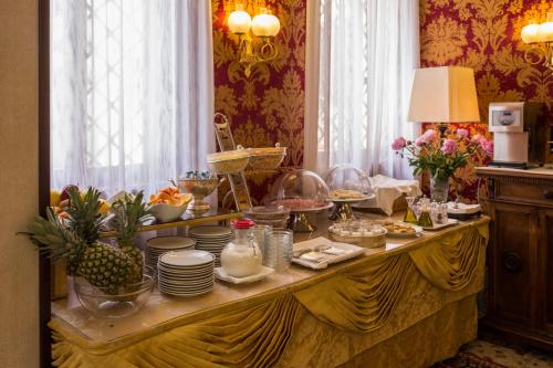 un buffet con comida y platos en una mesa en Hotel Bel Sito e Berlino, en Venecia