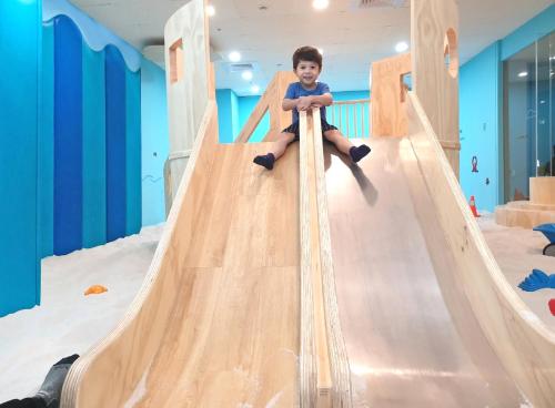 a young boy sitting on a slide at a indoor playground at Ambassador Hotel Hsinchu in Hsinchu City