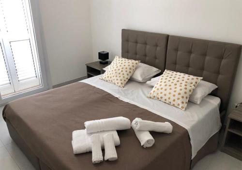 une chambre avec un grand lit avec des serviettes dessus dans l'établissement 3G BAROQUE APARTMENTS, à Lecce