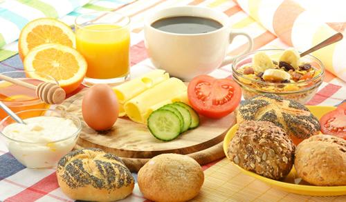 - une table avec des aliments pour le petit-déjeuner et une tasse de café dans l'établissement Schloss Kirchham, à Kirchham