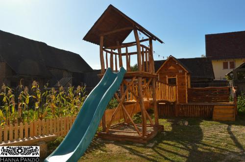 un parque infantil de madera con un tobogán en un patio en Pensiune Agroturistica Hanna en Ocland