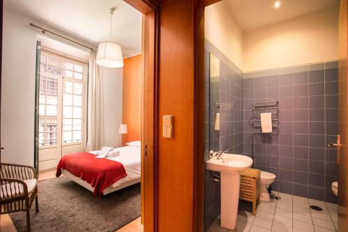 1 dormitorio con 1 cama y baño con lavamanos en Porto by the River 1, en Oporto