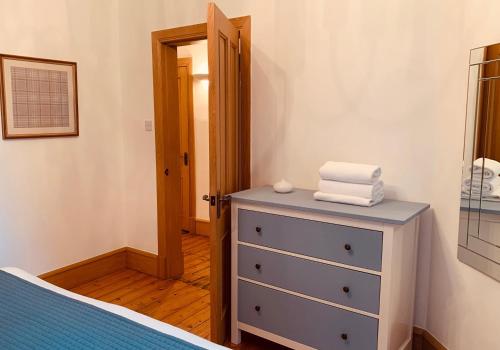 a bedroom with a blue dresser and a mirror at The Royal Mile Residence by Reserve Apartments in Edinburgh