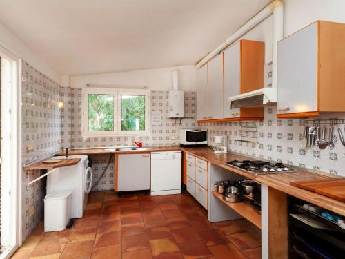 a kitchen with white cabinets and a tile floor at Holiday Home Villa Cassiopee by Interhome in Llança