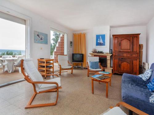 sala de estar con sofá, sillas y TV en Holiday Home Villa Cassiopee by Interhome, en Llançà