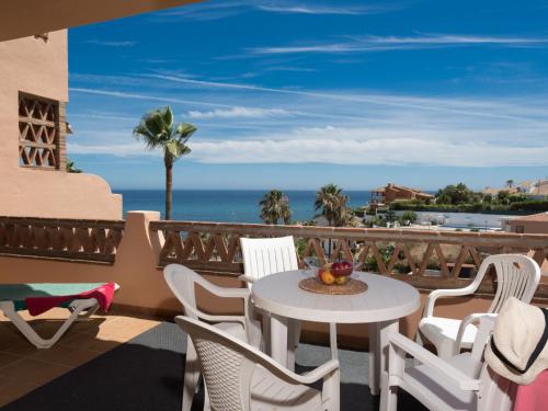 a balcony with a table and chairs and the ocean at Apartment La joya by Interhome in Fuengirola