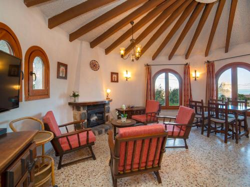 uma sala de estar com cadeiras e mesas e uma lareira em Holiday Home Silene by Interhome em La Canuta