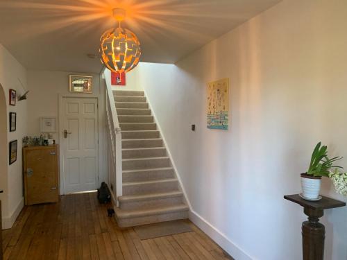 a hallway with stairs and a chandelier at Picaroons Bed and Breakfast in Sheringham