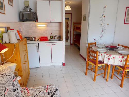 une cuisine avec des armoires blanches et une table et des chaises dans l'établissement Apartment Aurore-4 by Interhome, à La Grande Motte