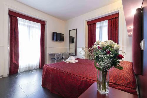 a hotel room with a vase of flowers on a table at Imperial Suite Guest House in Rome