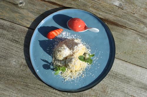 a blue plate with food on a wooden table at Boutique-Pension Jägerwirt in Scheffau am Wilden Kaiser