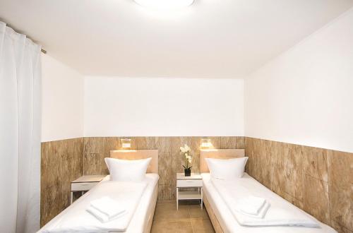 two beds in a room with two tables at S-HOF in Sonnenbühl