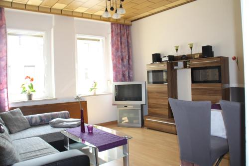 uma sala de estar com um sofá e uma televisão em Ferienwohnung Michalla em Thale