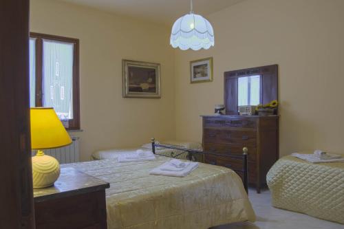 a bedroom with a bed and a dresser and a lamp at Montanari Agrivillage in Narni