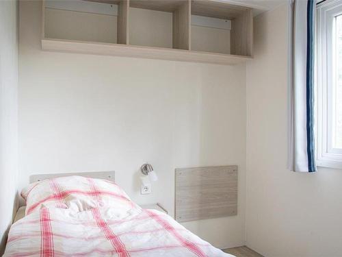 1 dormitorio con 1 cama con manta roja y blanca en Ferienhaus Kutschenmeyer, en Schneverdingen