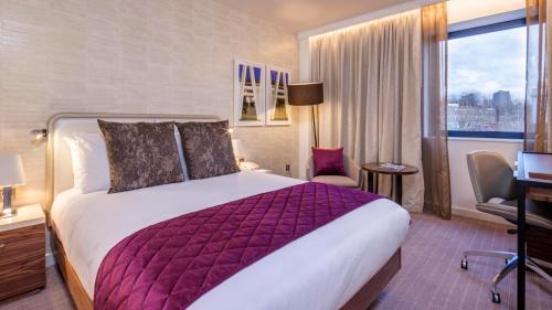 a hotel room with a large bed and a window at Crowne Plaza London Kings Cross by IHG in London