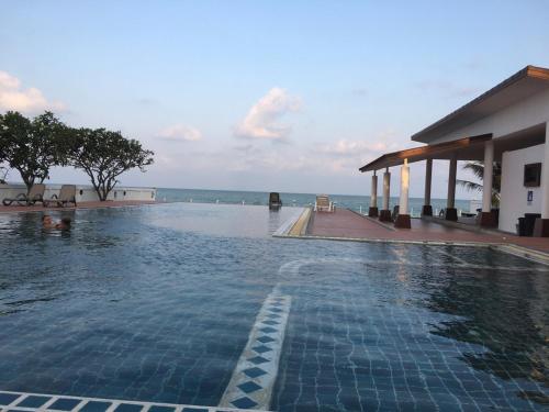a swimming pool with the ocean in the background at Khanom Beach Residence Monthly Rental Condo in Khanom