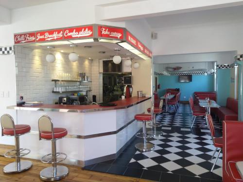 a restaurant with a bar with red stools at Savoy Hotel Beaufort-West in Beaufort West