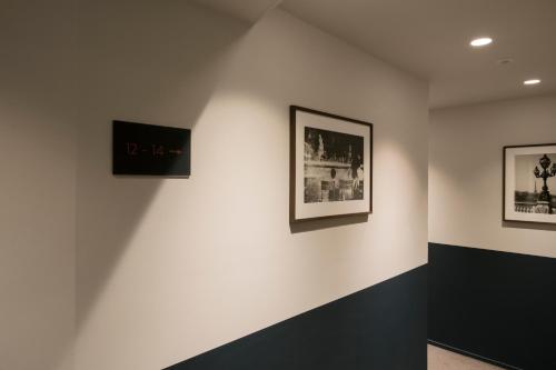 een kamer met zwart-witte foto's aan de muur bij Hotel Monsieur Helder in Parijs