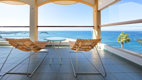 a balcony with chairs and a table and the ocean at BULL Dorado Beach & SPA in La Playa de Arguineguín