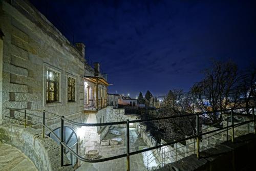 a stone building with a railing and stairs at night at Naraca Cave House in Göreme