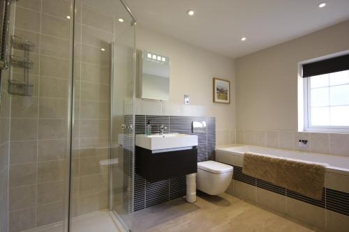 ein Badezimmer mit Waschbecken, Toilette und Dusche in der Unterkunft Flintstone Cottages in Chichester