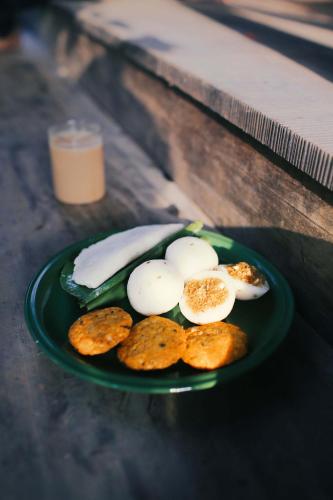 a green plate with eggs and crackers on a table at Chittoor Kottaram Royal Mansion - A CGH Earth SAHA Experience in Cochin