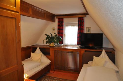 ドナウヴェルトにあるPension Haus Gertrudのベッド2台とテレビが備わる屋根裏部屋です。