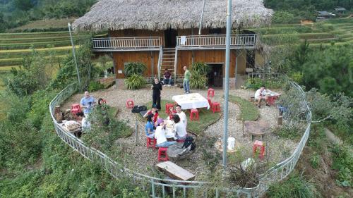 a group of people sitting in front of a house at Hello Mu Cang Chai Homestay & Tours in Mù Cang Chải