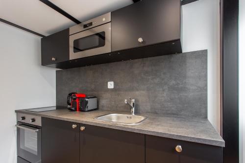 a kitchen with a sink and a microwave at Luxury loft in paris in Paris
